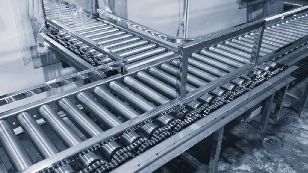 Stainless steel roller conveyor system used for automated material handling inside a refrigerated warehouse facility.