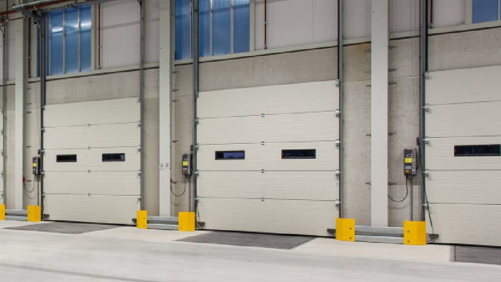 Insulated loading dock doors with dock levelers and sealed entry points for temperature transition control in a refrigerated warehouse.